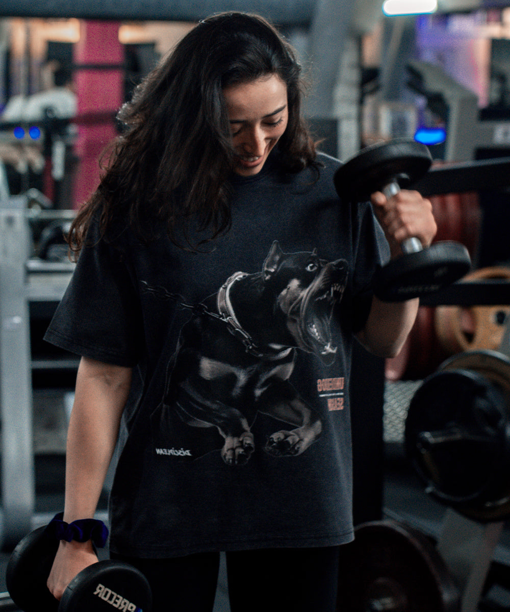 Athlète féminine portant un t-shirt oversize type pump cover vintage dans une salle de sport