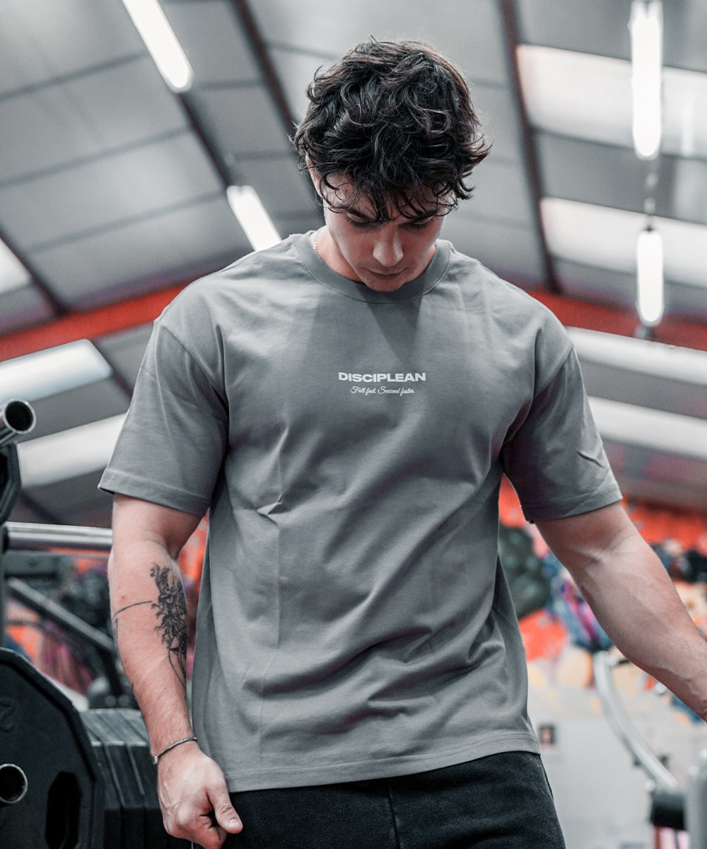 Homme de face en salle de musculation portant un pump cover gris Disciplean