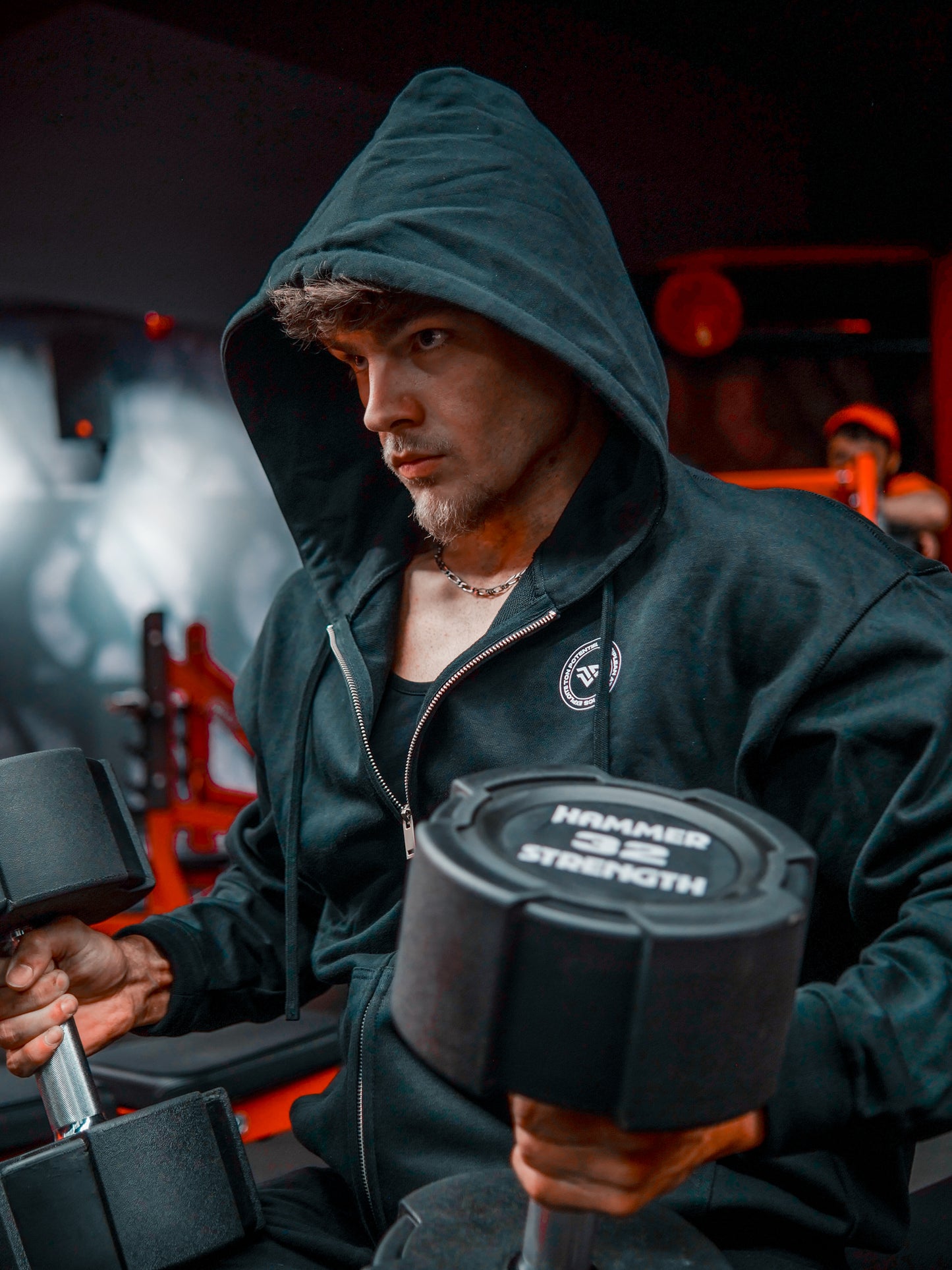 Homme de face en salle de musculation portant un sweat avec zip noir Disciplean