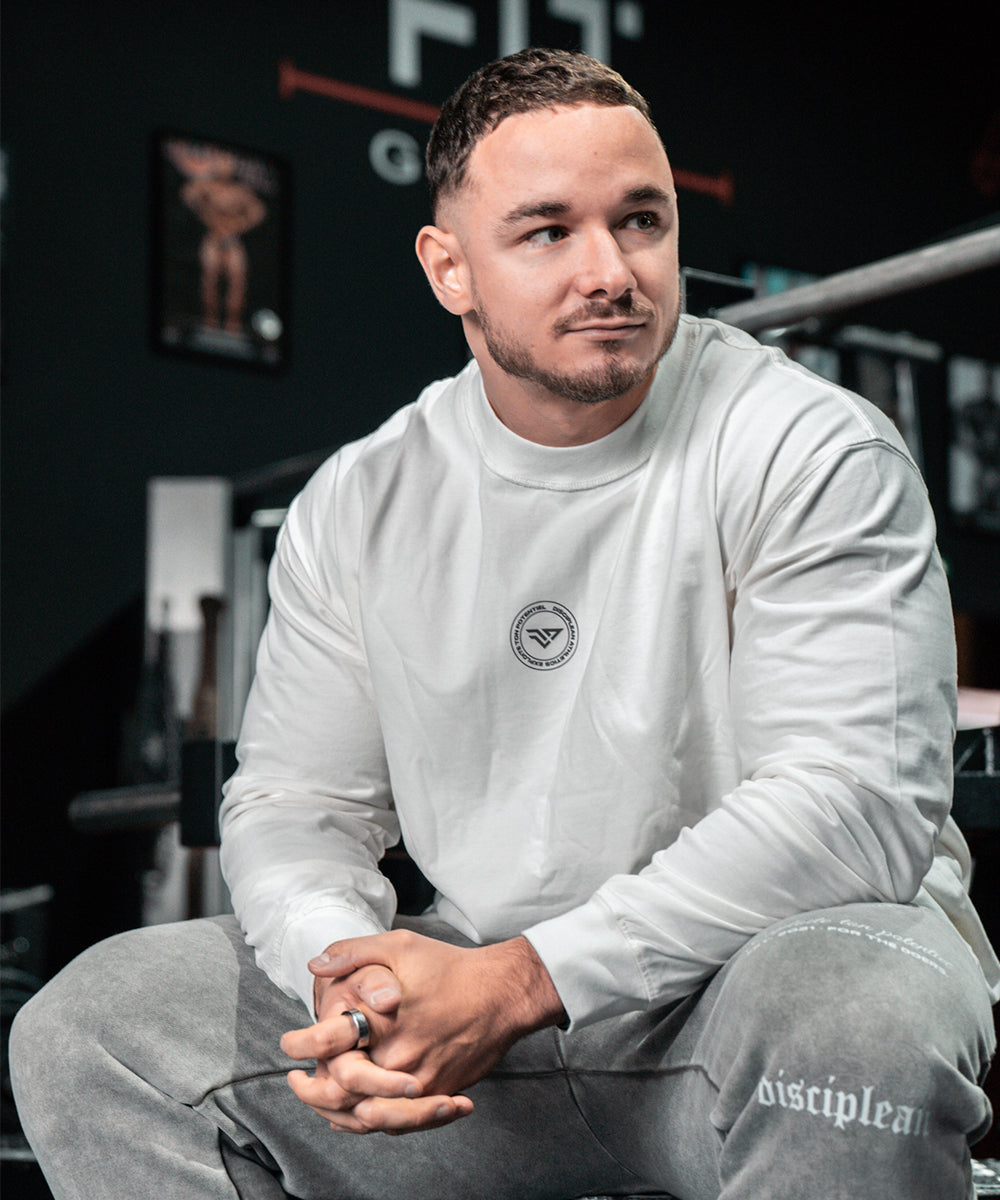 Athlète portant un t-shirt de musculation blanc dans une salle de sport