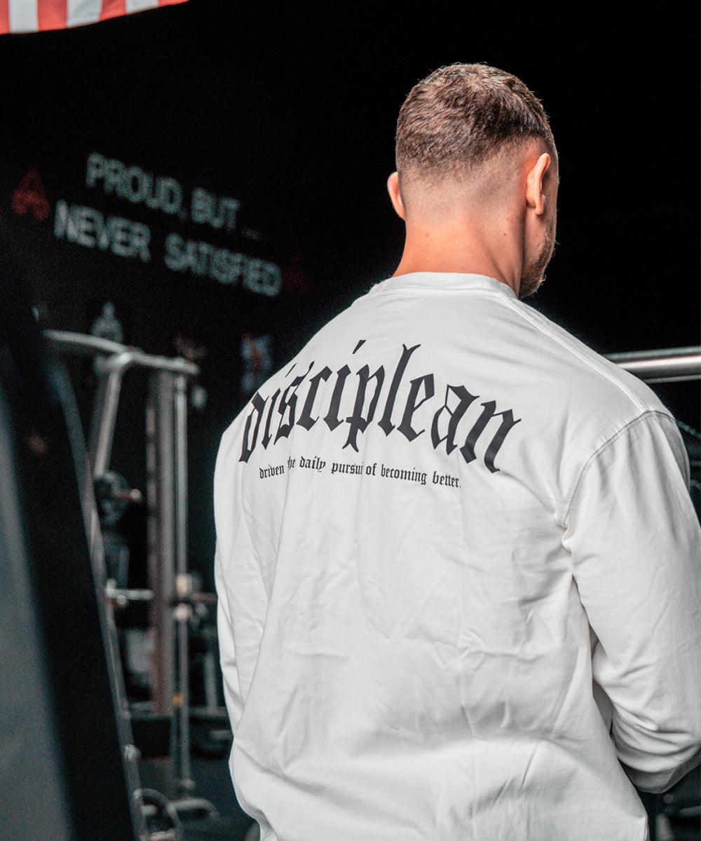 Athlète portant un t-shirt de sport à manches longues blanc dans une salle de sport