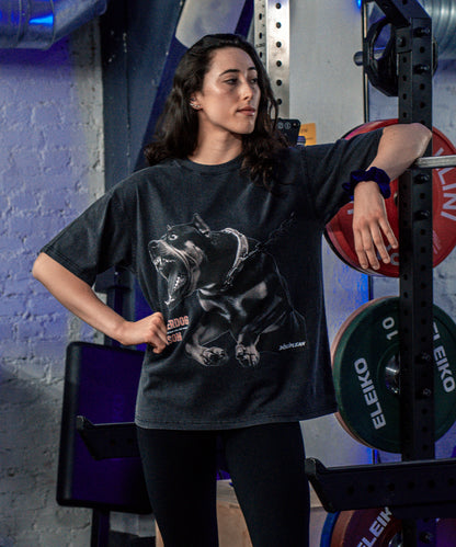 Athlète féminine portant un t-shirt oversize type pump cover vintage dans une salle de sport