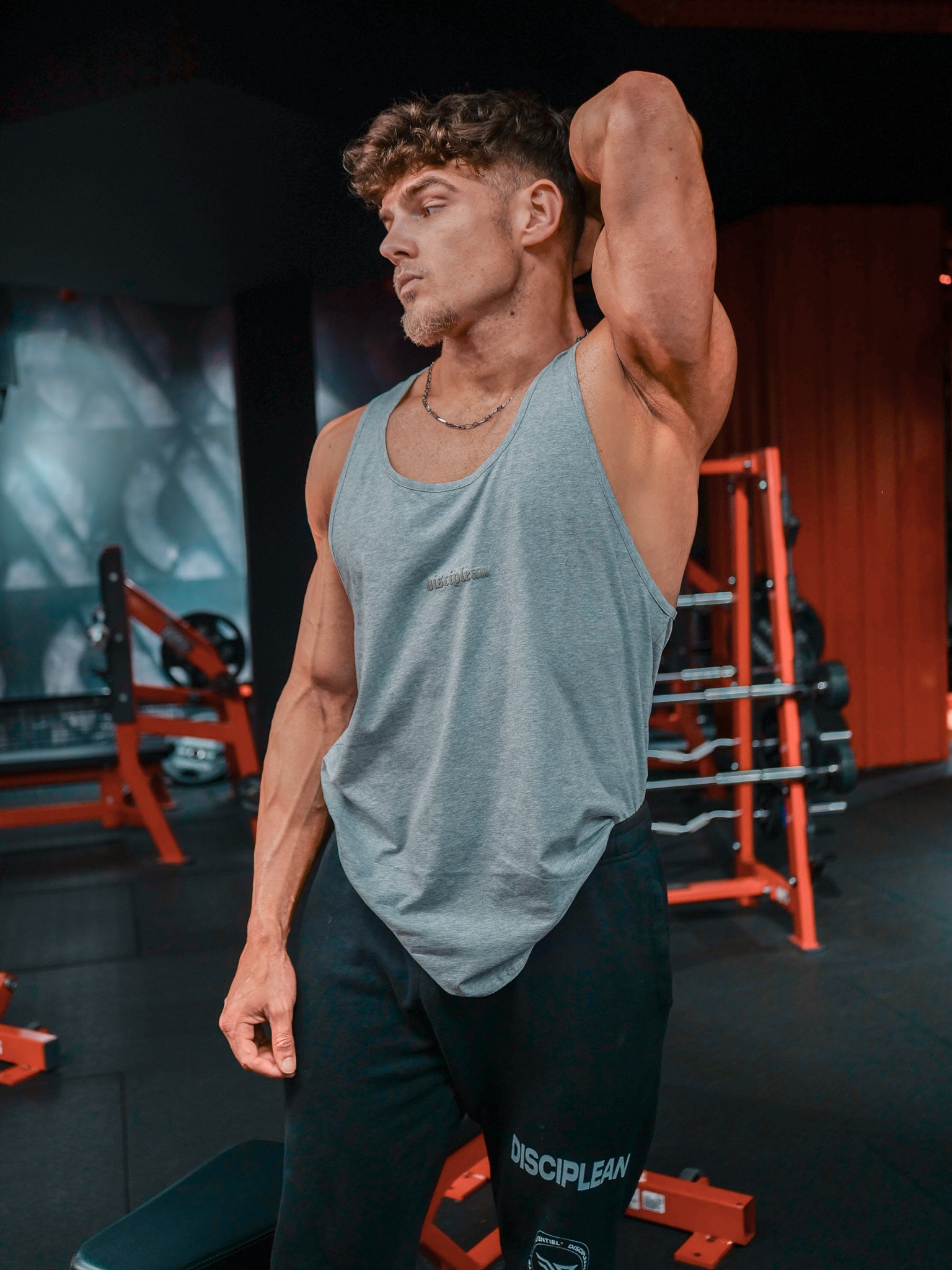 Homme de face en salle de musculation portant un débardeur gris Disciplean