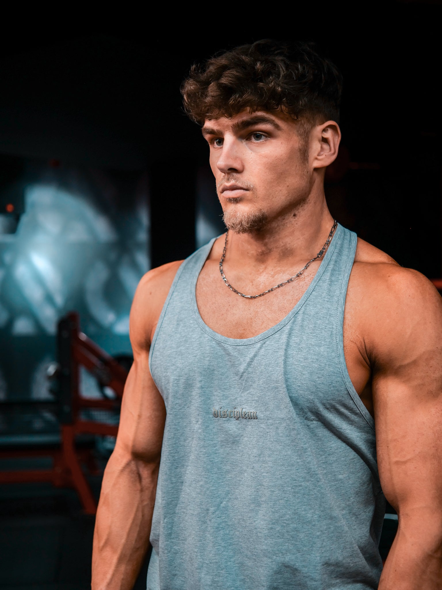 Homme de face en salle de musculation portant un débardeur gris Disciplean