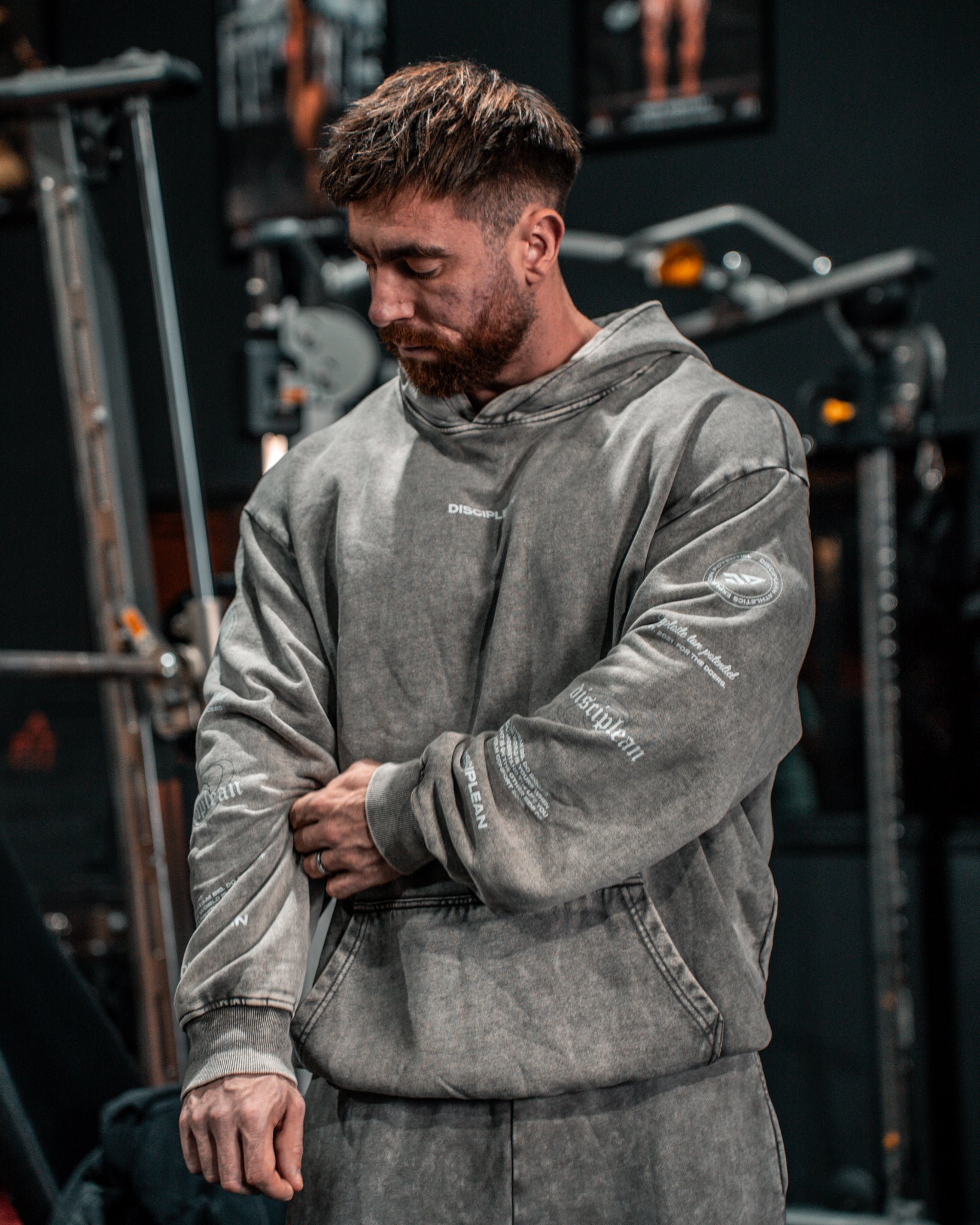 Homme de face en salle de musculation portant un hoodie gris Disciplean