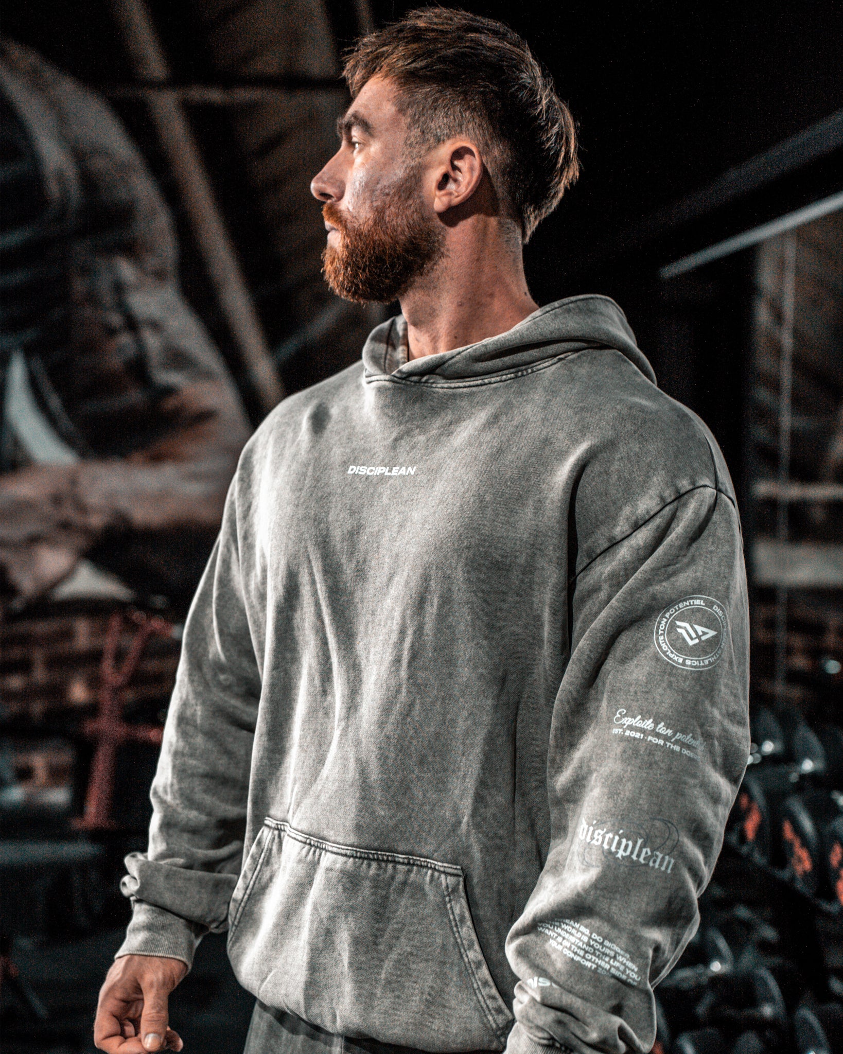 Homme de face en salle de musculation portant un hoodie gris Disciplean