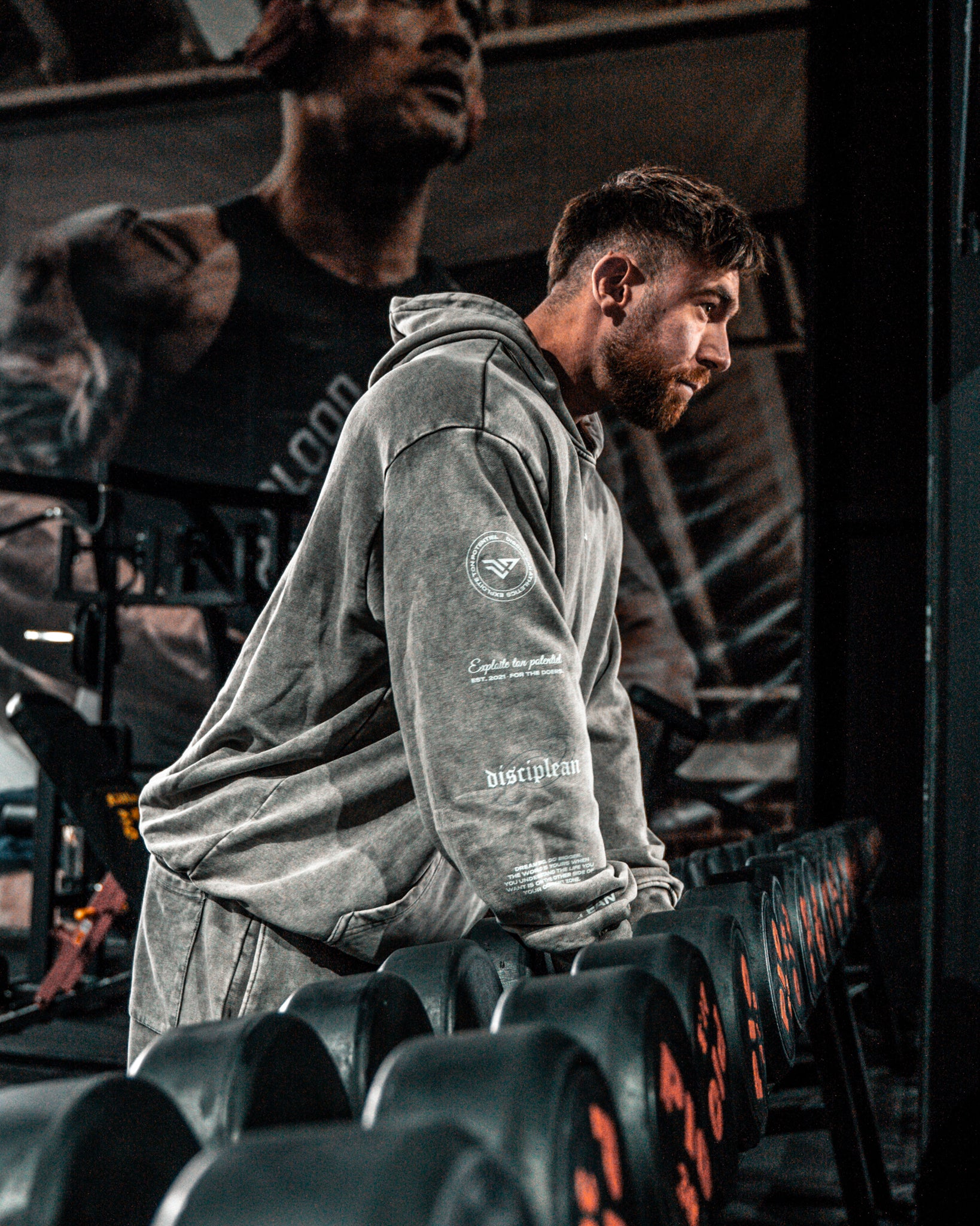 Homme de face en salle de musculation portant un hoodie gris Disciplean