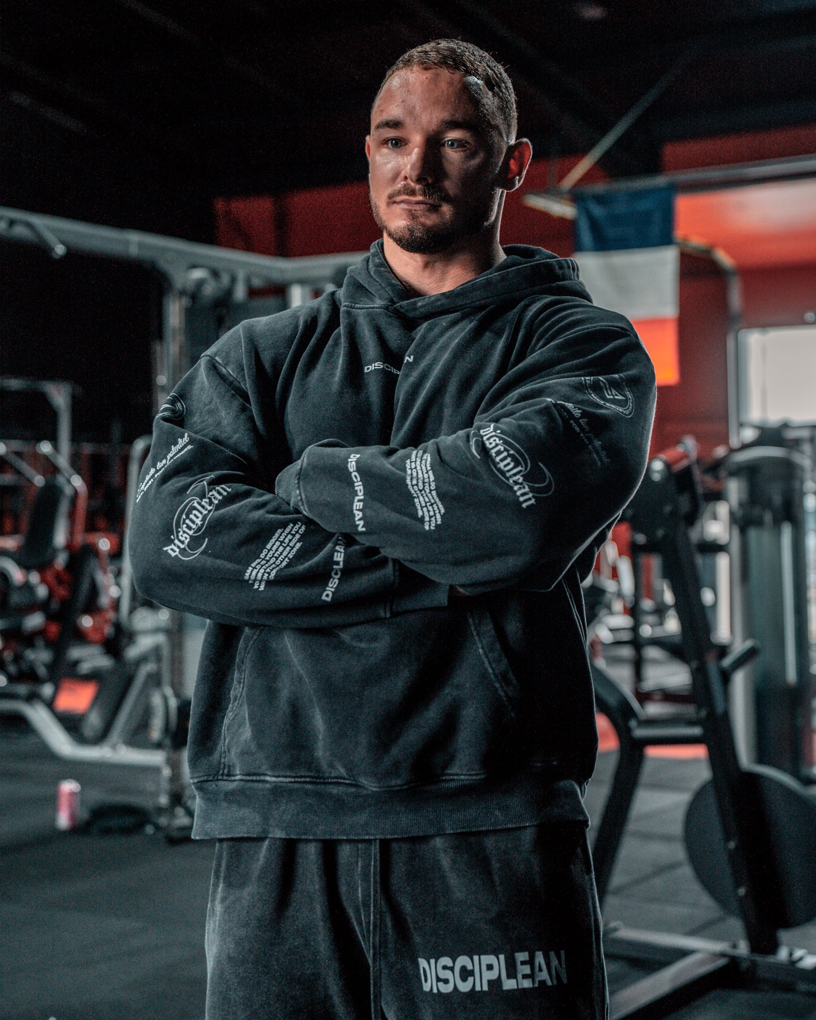 Homme de face en salle de musculation portant un hoodie noir Disciplean