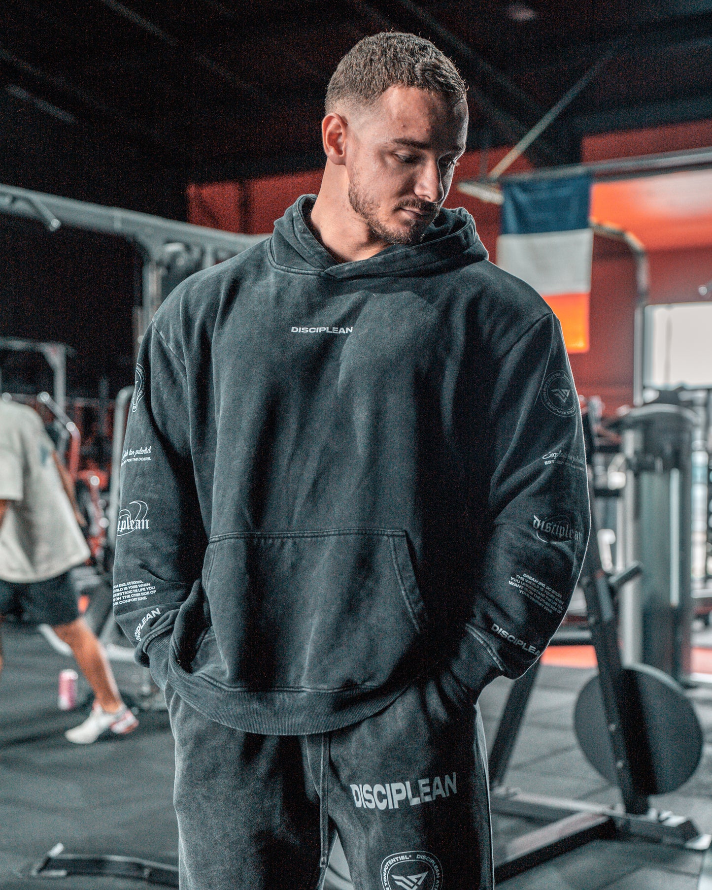 Homme de face en salle de musculation portant un hoodie noir Disciplean