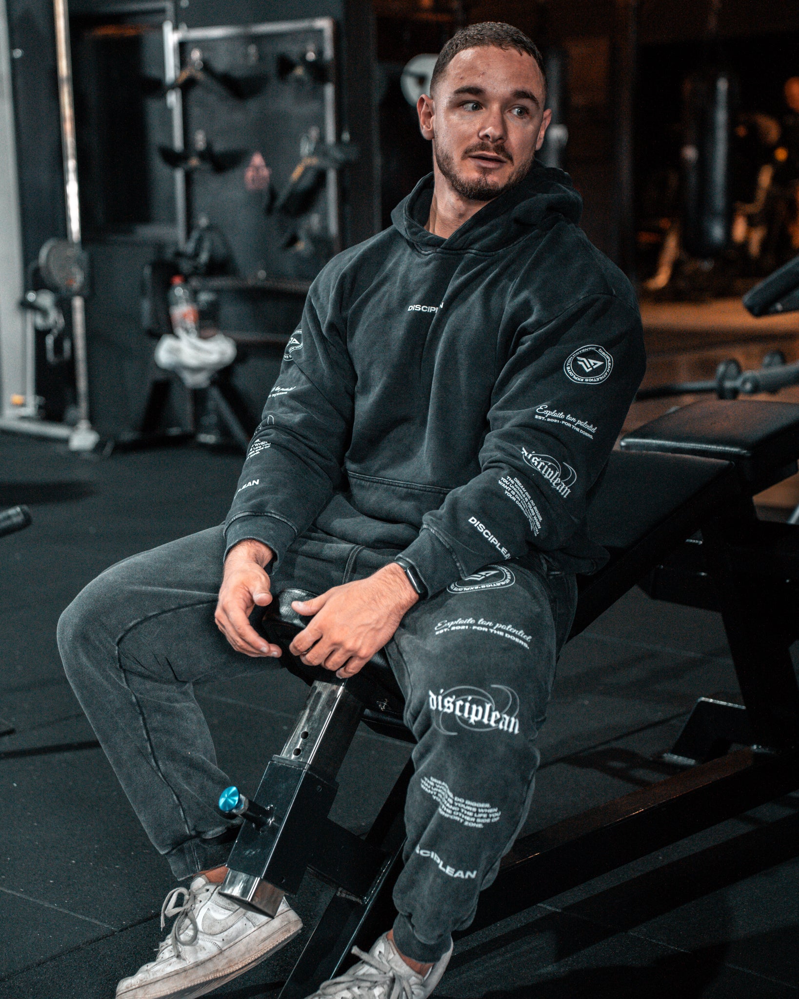 Homme de face en salle de musculation portant un hoodie noir Disciplean