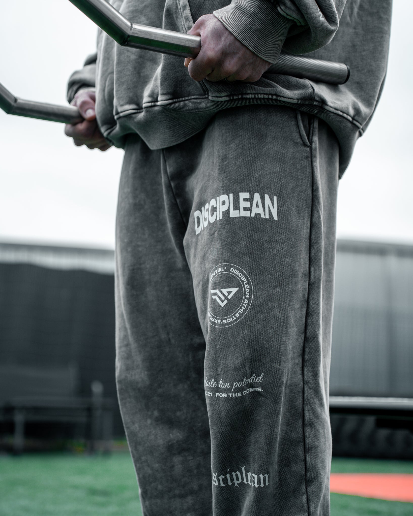 Homme de face en salle de musculation portant un jogging gris Disciplean