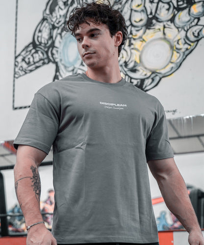 Homme de face en salle de musculation portant un pump cover gris Disciplean